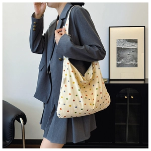Detail of canvas tote bag with colorful polka dots and MISS label on side