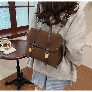 Detail of retro brown frosted suede backpack with leather straps in a cozy cafe setting
