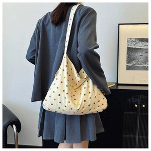 Close-up of large canvas tote bag featuring vibrant colorful polka dots for daily commute