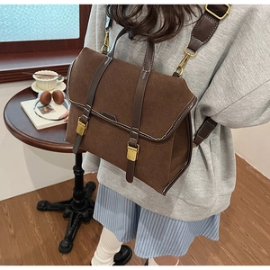 Detail eines braunen Vintage-Rucksacks mit Goldverschluss und stabilen Tragegurten