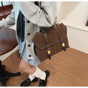 Detail view of the brown retro messenger bag with gold buckles and matte texture finish