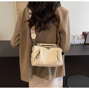 Detail of white litchi pattern leather pillow bag with wide woven shoulder strap