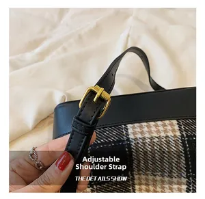 Détail de la bandoulière réglable en cuir noir avec boucle dorée sur le sac à carreaux