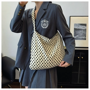 Polka dot canvas tote bag with black EMIS logo label, crossbody style on model