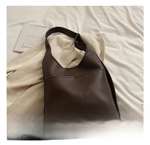 Detailed view of dark brown faux leather shoulder bag with textured lychee grain finish