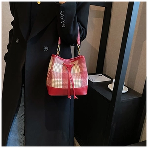Détail du sac seau en cuir rouge et tissu pied-de-poule avec fermeture à cordon