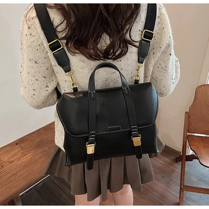 Rückansicht des Modells mit klassischem schwarzem Lederrucksack und Goldschnallen