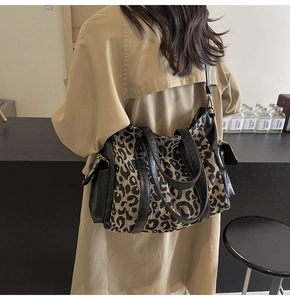 Close-up of leopard print canvas tote bag with black leather trim and double shoulder straps