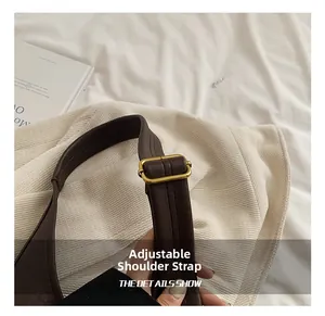 Detail shot of the adjustable leather shoulder strap with a golden buckle on a brown bag