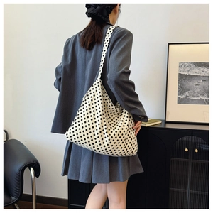 Detailed view of canvas tote bag featuring stylish black polka dots and soft texture