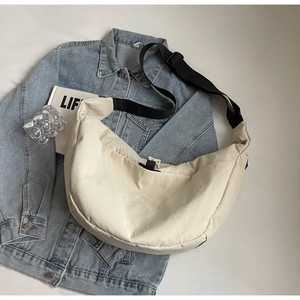 Detail of cream nylon crescent crossbody bag with adjustable wide black strap