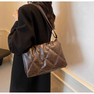 Close-up of deep brown quilted faux leather tote bag with soft vintage matte texture
