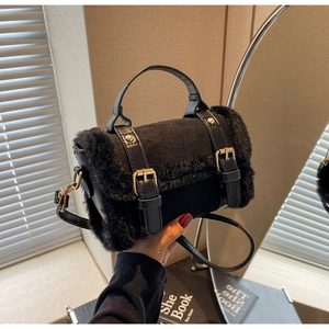 Dettaglio borsa a tracolla in peluche nero con hardware dorato e finitura opaca morbida