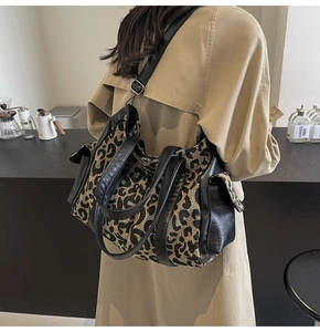 Detailed back view of leopard print tote bag featuring black leather trim and side pocket