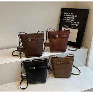 Detail of four retro bucket bags in dark coffee, burgundy, black and khaki faux leather