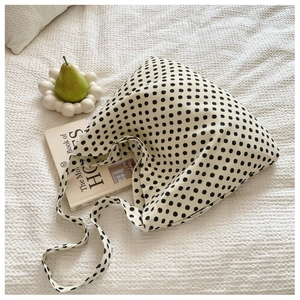 Close-up of a large canvas hobo tote bag featuring a classic black and white polka dot pattern