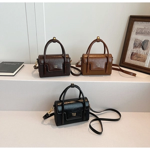 Three retro mini handbags in brown, caramel, and black with shiny finish and gold logo