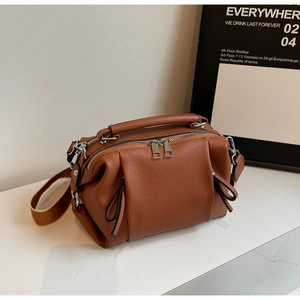 Close-up of brown lychee grain leather doctor bag with silver hardware and bow detail