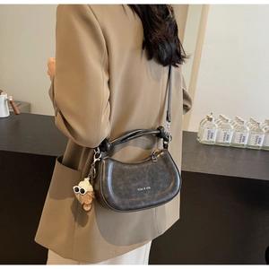 Modellansicht einer Vintage-Satteltasche mit Knotengriff und Plüsch-Anhänger-Detail