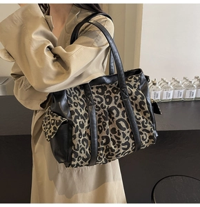 Macro shot of large leopard print tote bag detailing canvas texture and side pocket