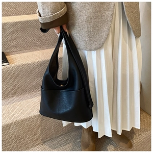 Detail of black pebbled leather hobo bag with elegant stitching and metallic closure