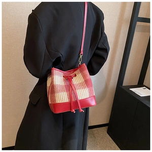 Détail du sac seau à motif pied-de-poule rouge avec cordon en cuir et dorures