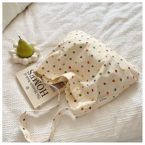 Detailed close-up of a canvas tote bag featuring a multi-colored polka dot pattern print
