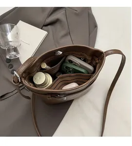 Top-down view of the spacious interior of the brown bucket bag showing daily essentials