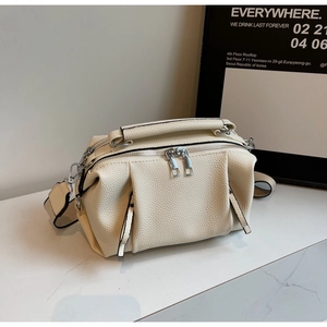 Close-up of cream white pleated pillow bag with lychee grain leather and silver hardware