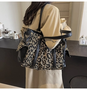 Detail shot of leopard print canvas tote bag featuring premium black leather accents