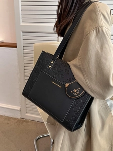 Elegante schwarze Tragetasche mit Bärenprägung und goldenem Logo für den Alltag