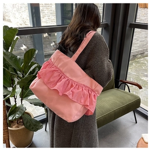 Pink canvas tote bag with ruffled pleats shown on shoulder of model from behind