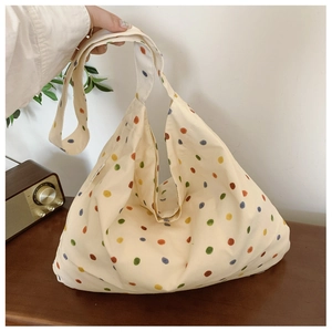 Close-up of beige canvas tote bag with multi-colored polka dots and soft texture