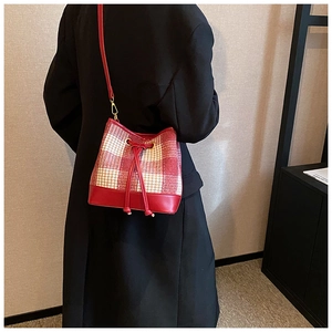 Détail du sac seau à motif pied-de-poule rouge avec cordon de serrage et métal doré