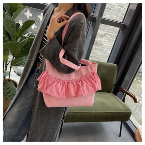 Detailed view of pink ruffled tote bag shown in a lifestyle scene with canvas texture
