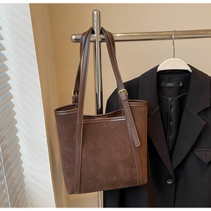 Detail of dark brown matte tote bag hanging with a blazer for a professional look