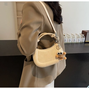 Detailansicht beige Satteltasche mit geknotetem Griff und süßem Plüschball-Anhänger am Riemen