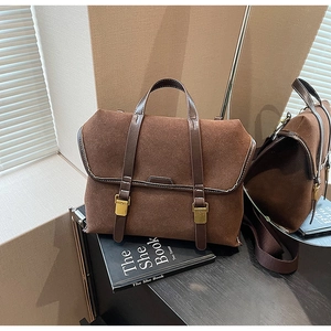 Nahaufnahme von dunkelbraunem Wildleder und Leder mit Vintage-Goldschnalle-Detail