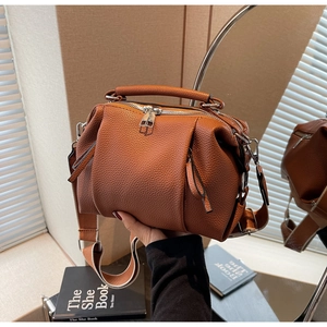 Detail of caramel pleated cross-body bag with lychee texture and wide strap