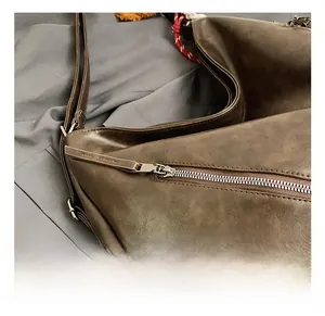 Dettaglio della cerniera in metallo e della pelle marrone su una borsa tote vintage
