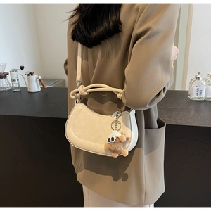 Beige Satteltasche mit lustigem Plüsch-Anhänger, getragen zum stylischen Oliven-Blazer