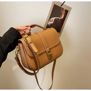 Close-up of caramel textured leather crossbody bag with golden square twist lock
