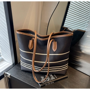 Detail showing high-quality canvas fabric with striped accents and leather straps