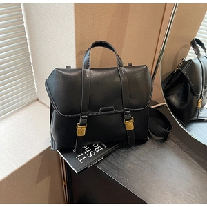 Details einer schwarzen Vintage-Aktentasche mit Goldschnallen und Kontrastnähten
