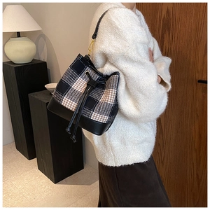 Détail du sac seau à carreaux avec cordon en cuir et motif pied-de-poule rétro