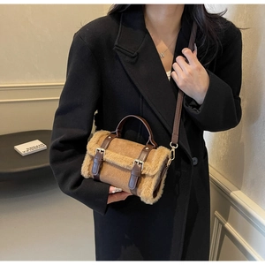 Dettaglio del bordo in pelliccia sintetica e fibbie in pelle su borsa Boston marrone