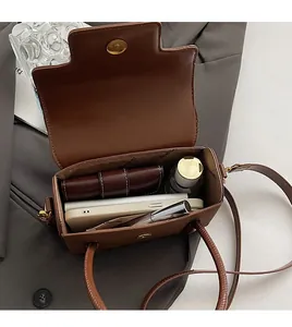 Detailed view showing storage capacity of the dark brown square bag for phone and makeup