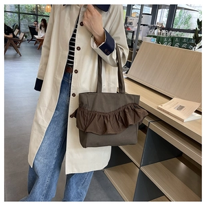 Detail of dark brown canvas tote bag featuring stylish ruffle pleats on stylish ruffles