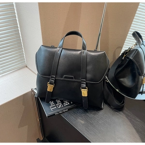Detailansicht der schwarzen matten Ledertasche mit Kontrastnaht und goldenen Schnallen