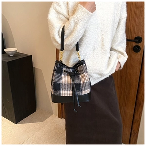 Détail du sac seau à carreaux rétro avec cordon de serrage et empiècements en cuir